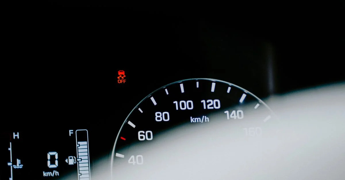 Gros plan détaillé d'un compteur de vitesse de voiture affichant une lecture numérique et un voyant d'avertissement.